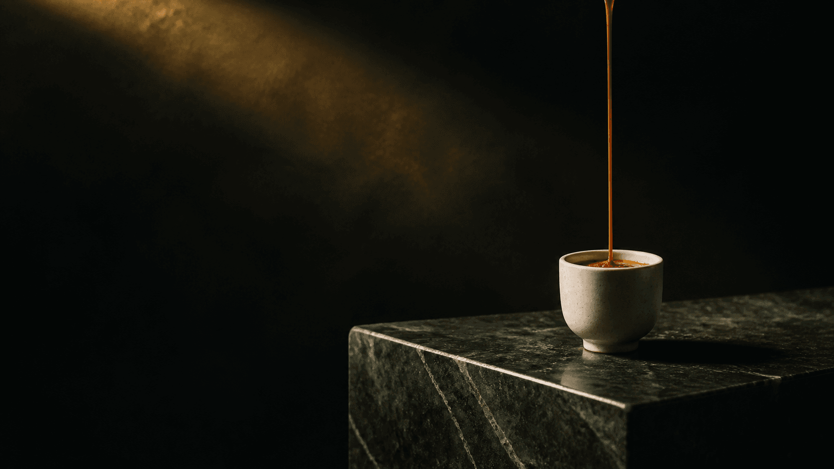 Espresso servido sobre bloco escultórico de pedra verde